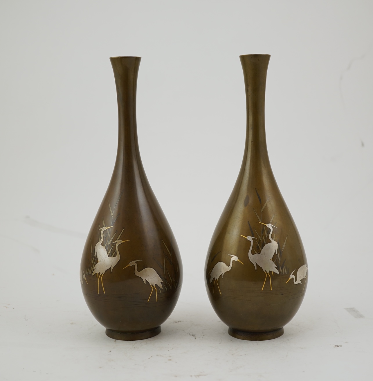 A pair of Japanese bronze and mixed metal inlaid bottle vases, signed Hidemitsu, Meiji period